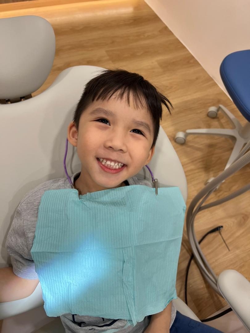 A young patient smiling in the dental chair